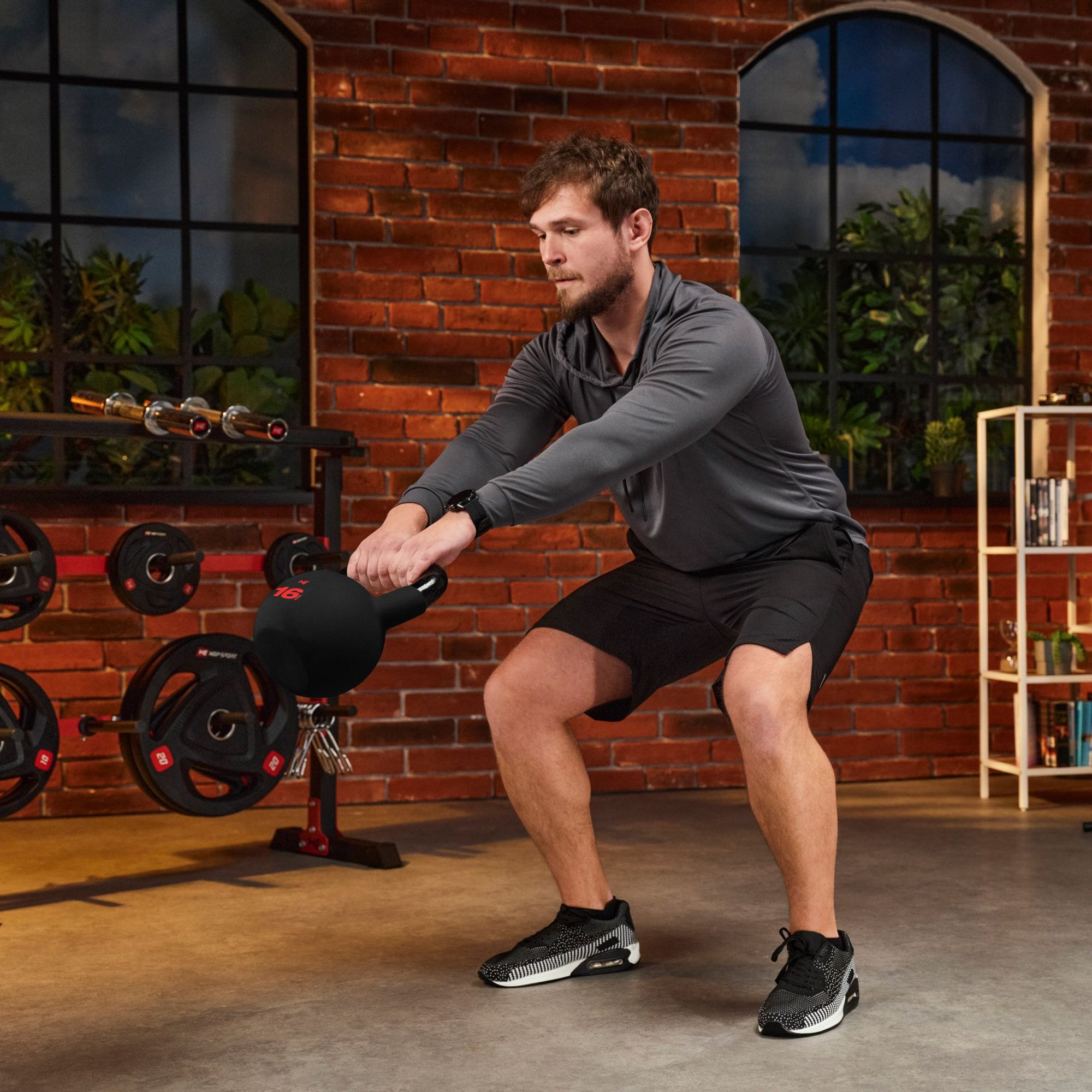 Mann führt eine Kettlebell-Übung mit einer Hop-Sport Kettlebell im Home-Gym aus