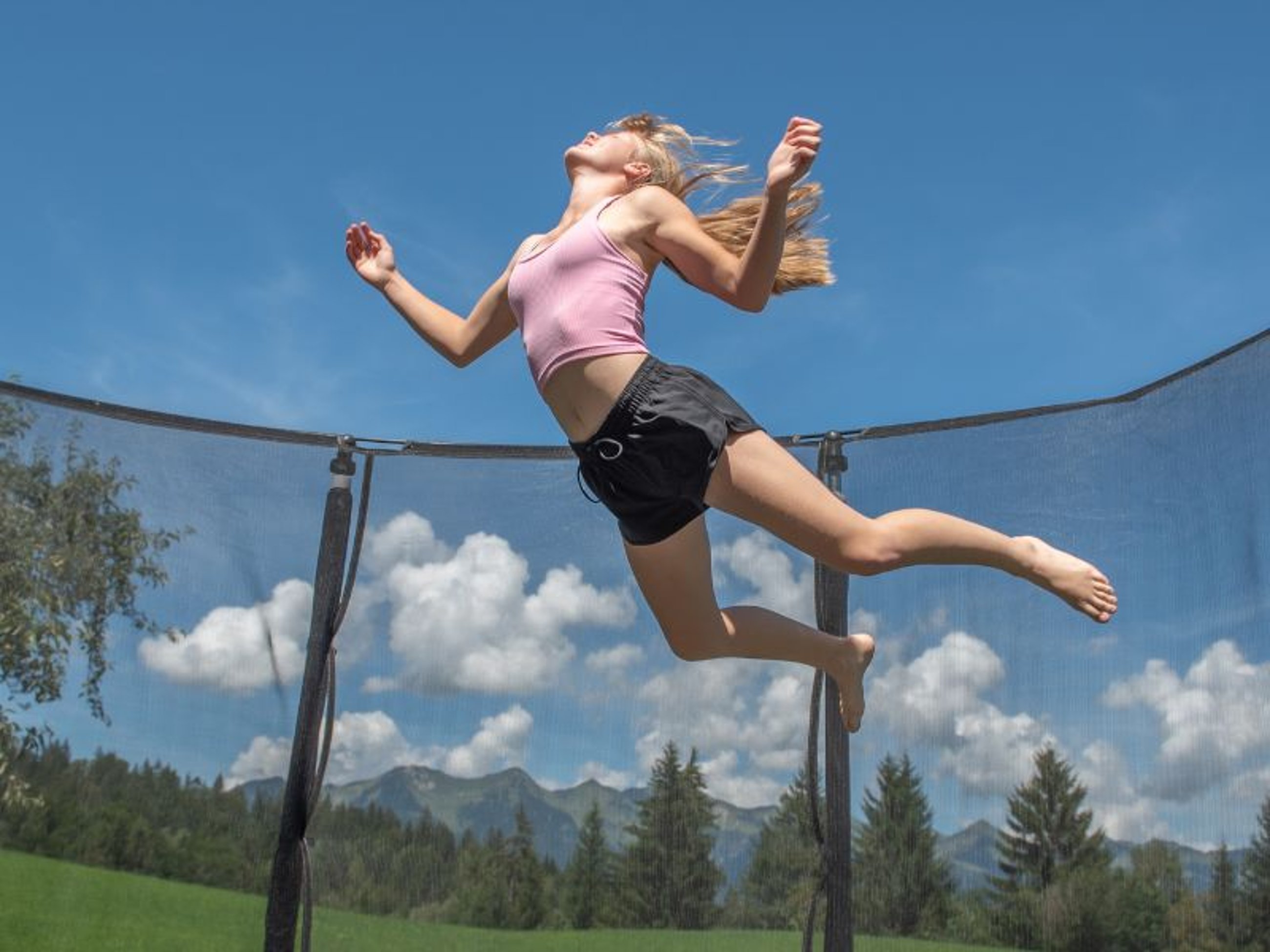Glückliches Mädchen springt auf einem Trampolin 