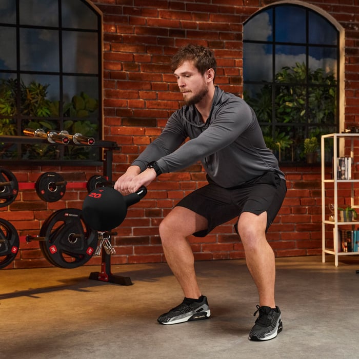 Mann führt eine Kettlebell-Übung mit einer Hop-Sport Kettlebell im Home-Gym aus