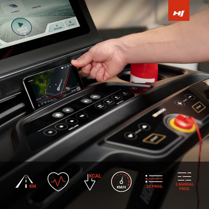 Fotomodel verwendet während des Trainings einen Handy- oder Tablet-Halter, der sich unter dem TFT-Touchscreen befindet.