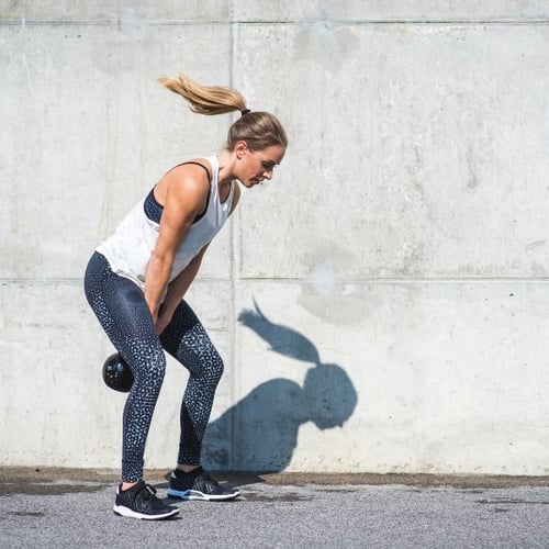 Frau beim Kettlebell-Training im Freien als Rudermaschine-Alternative