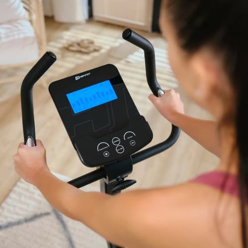 Ergometer Training zu Hause: Nahaufnahme der Konsole eines Hop-Sport Heimtrainers mit blau beleuchtetem Display und Steuerknöpfen.