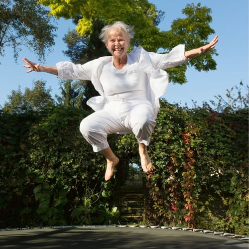 Eine ältere Frau springt auf einem Trampolin