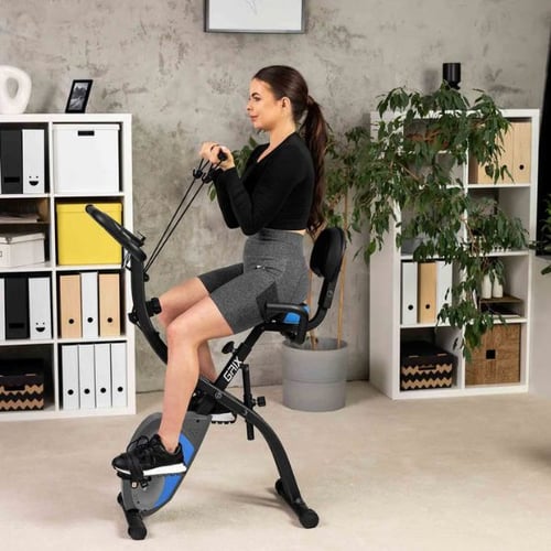 Frau trainiert mit Zugbändern auf klappbarem Heimtrainer von Hop-Sport