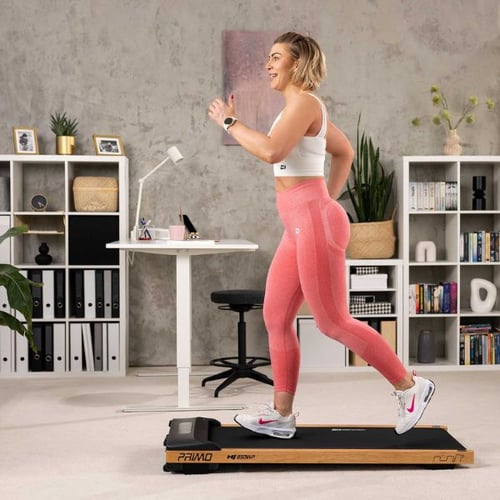 Frau in rosa Leggings läuft auf einem Hop-Sport PRIMO HS-2200WF Laufband in einem modern eingerichteten Raum