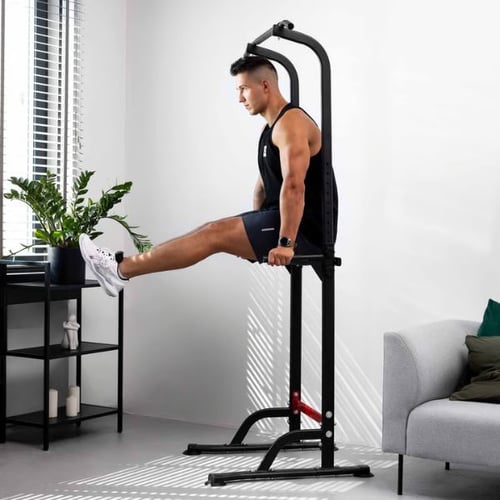 Mann macht Beinheben an Dip-Station von Hop-Sport