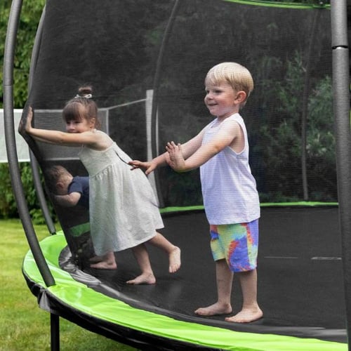 Kinder spielen auf einem Hop-Sport Trampolin mit grünem Sicherheitsnetz