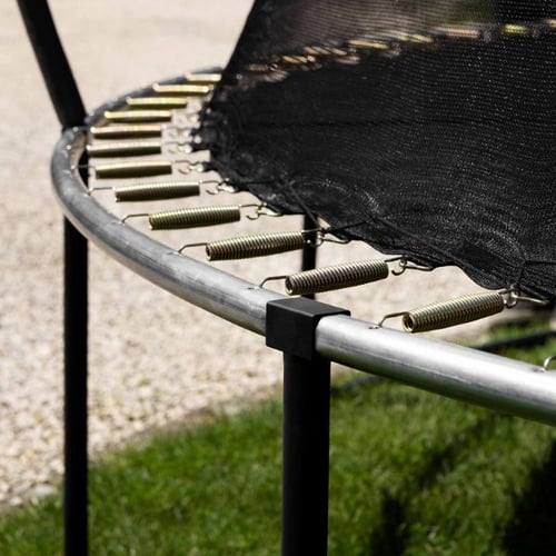 Federsystem und runder Metallrahmen beim Aufbau eines Hop-Sport Trampolins im Garten