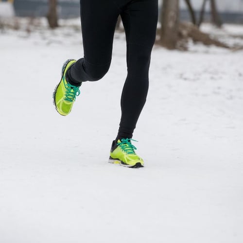 Jogger läuft im Winter auf Schnee und achtet auf gleichmäßige Atmung