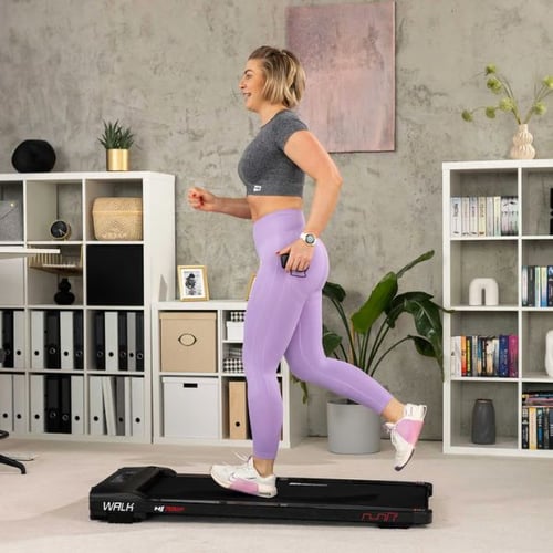 Frau joggt auf Hop-Sport Laufband in modernem Wohnzimmer