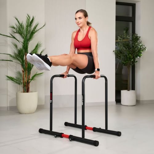 Frau macht Beinheben an Hop-Sport Dip Barren mit engem Abstand