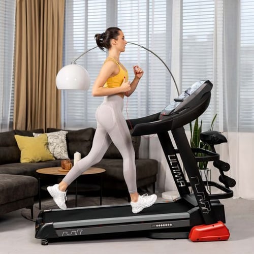 Frau joggt auf dem Hop-Sport Laufband Ultima im Wohnzimmer
