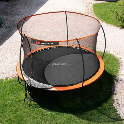 Rundes Hop-Sport Trampolin mit Sicherheitsnetz, Leiter und orangenen Akzenten, aufgebaut auf einer Wiese