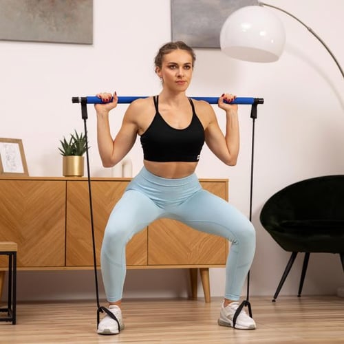 Frau trainiert mit Hop-Sport Fitnessstange und Widerstandsbändern – effektives Pilates Zubehör