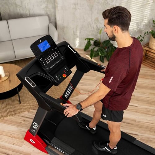 Mann bedient Hop-Sport Laufband und stellt Geschwindigkeit über Display ein