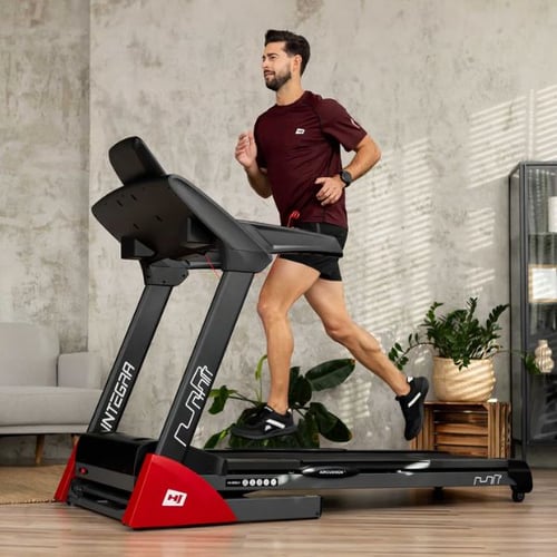 Mann läuft auf Hop-Sport Laufband beim Zone 2 Training im Wohnzimmer
