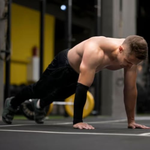  Mann in Plank-Position beim Calisthenics-Training auf Studioboden