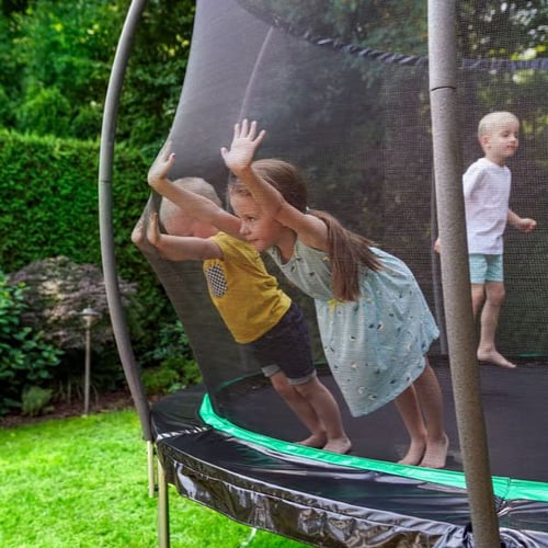 Drei Kinder spielen auf einem Hop-Sport Trampolin mit Netz