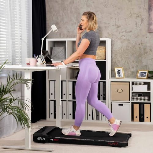 Frau arbeitet am Schreibtisch und geht auf dem Hop-Sport Laufband Walk