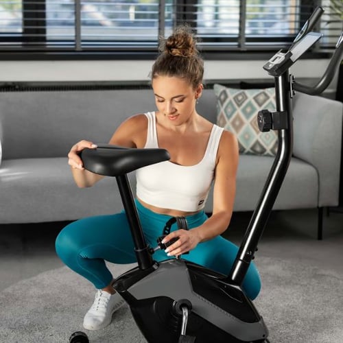 rau justiert den Sattel eines Hop-Sport Ergometer-Heimtrainers