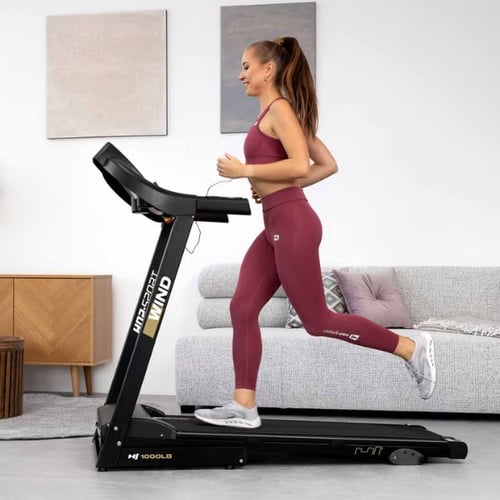 Frau joggt auf Hop-Sport Laufband im Wohnzimmer