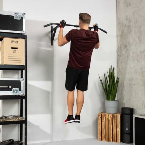 Mann macht Klimmzüge an Wand-Klimmzugstange von Hop-Sport