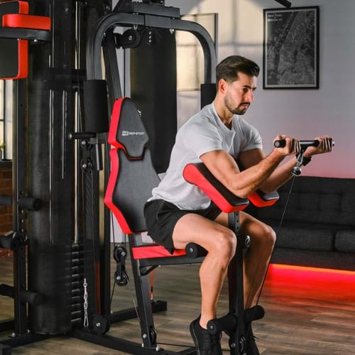 Mann führt Bizepscurl an Hop-Sport Kraftstation im Homegym aus