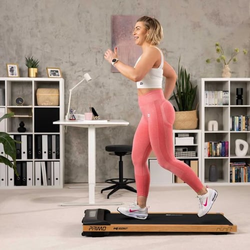 Frau läuft auf einem Hop-Sport PRIMO Walking Pad in einem modernen Home-Office.