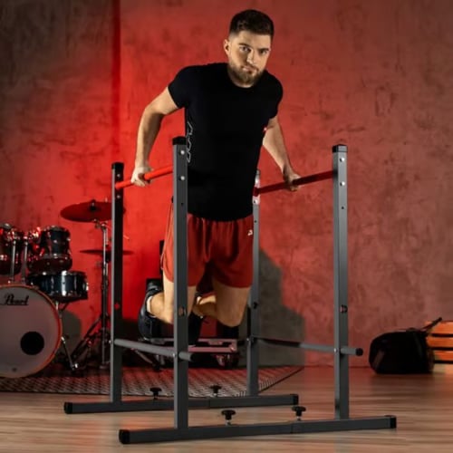 Mann trainiert Dips mit Gewicht an Hop-Sport Dip-Stangen