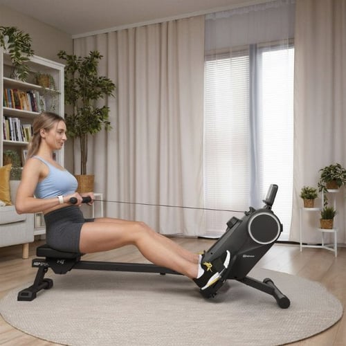 Frau nutzt ein Hop-Sport Rudergerät beim Rudern im Wohnbereich