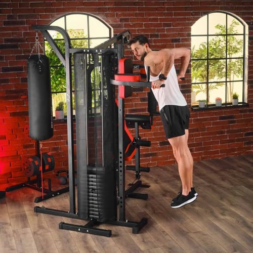 Mann macht Dips an Hop-Sport Kraftstation mit Boxsack im Homegym