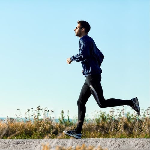 Mann joggt draußen bei schönem Wetter als Teil seines Zone 2 Trainings
