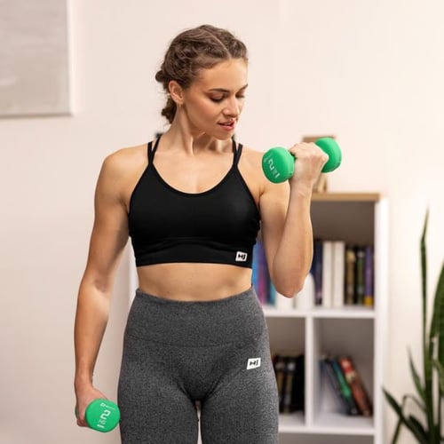 Frau trainiert mit grünen Hop-Sport Kurzhanteln zur Stärkung von Schultern und Rücken