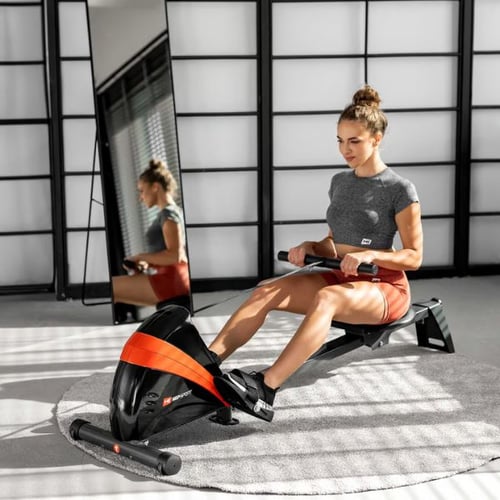 Frau nutzt Hop-Sport Rudergerät mit rotem Design für effektives Kalorienverbrennen im Heimtraining