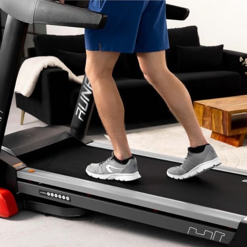  Mann geht auf dem Hop-Sport Laufband im Wohnzimmer