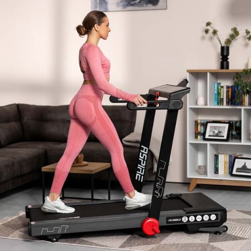 Frau geht auf dem Hop-Sport Laufband Aspire im Wohnzimmer
