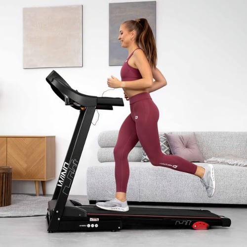 Frau läuft auf einem Hop-Sport Laufband im Wohnzimmer als Teil des Heimtrainings