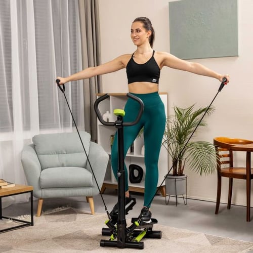 Frau trainiert auf Hop-Sport Stepper mit Widerstandsbändern im Wohnzimmer