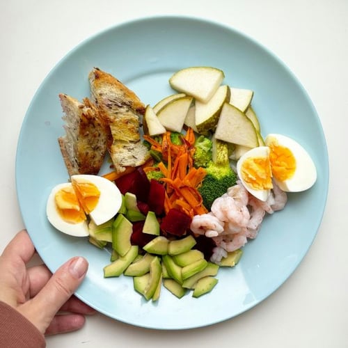 Gesunder Teller mit Ei, Avocado, Gemüse und Garnelen, leichte Mahlzeit nach Training auf leerem Magen