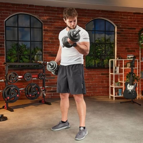 Mann trainiert Bizeps mit Kurzhanteln im Homegym, Muskeln zusammen trainieren mit Hop-Sport Hantelset