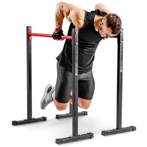 Mann trainiert mit Hop-Sport Dip Barren mit großem Abstand für Dips