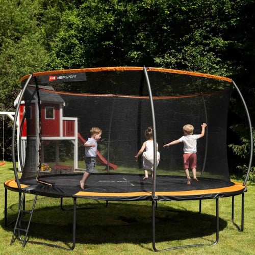 Kinder springen auf einem großen Hop-Sport Trampolin mit Sicherheitsnetz im Garten