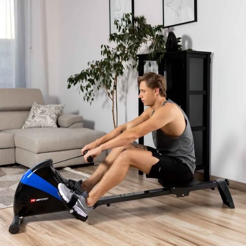 Mann trainiert zu Hause auf einem Hop-Sport Rudergerät 
