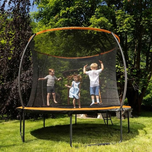 Kinder springen auf einem Hop-Sport Trampolin im Garten, umgeben von Sicherheitsnetz und grüner Natur.