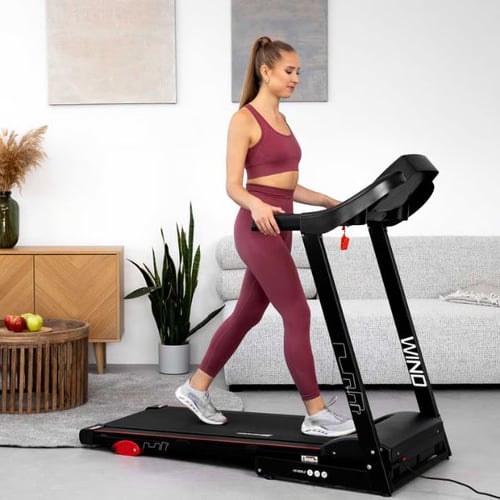 Frau trainiert auf Hop-Sport Laufband WIND im Wohnzimmer