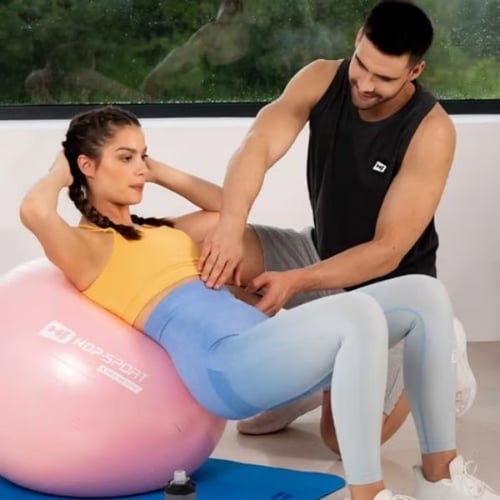 Bauchtraining mit Gymnastikball von Hop-Sport und Unterstützung durch Trainer