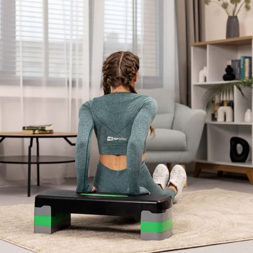 Frau trainiert Winkenarme und macht Trizeps-Dips auf Hop-Sport Aerobic Stepper