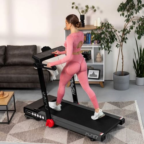 Frau nutzt das Hop-Sport Laufband mit regulierbarer Laufgeschwindigkeit im Wohnraum