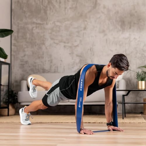 Bankdrücken Alternative: Mann trainiert mit einem Hop-Sport Fitnessband in Plank-Position auf einem Holzboden.