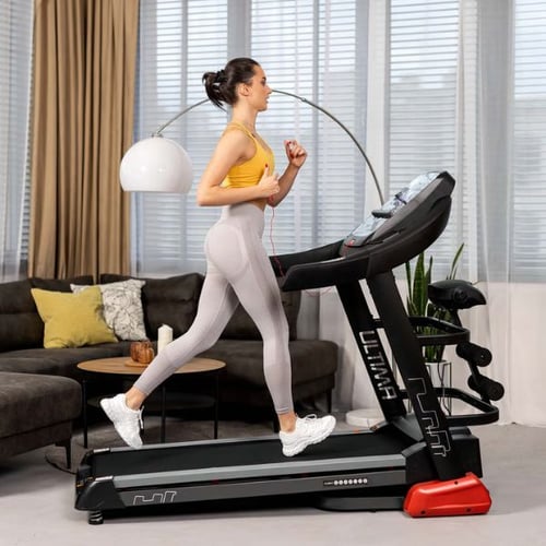 Frau joggt auf dem Hop-Sport Laufband im Wohnzimmer
